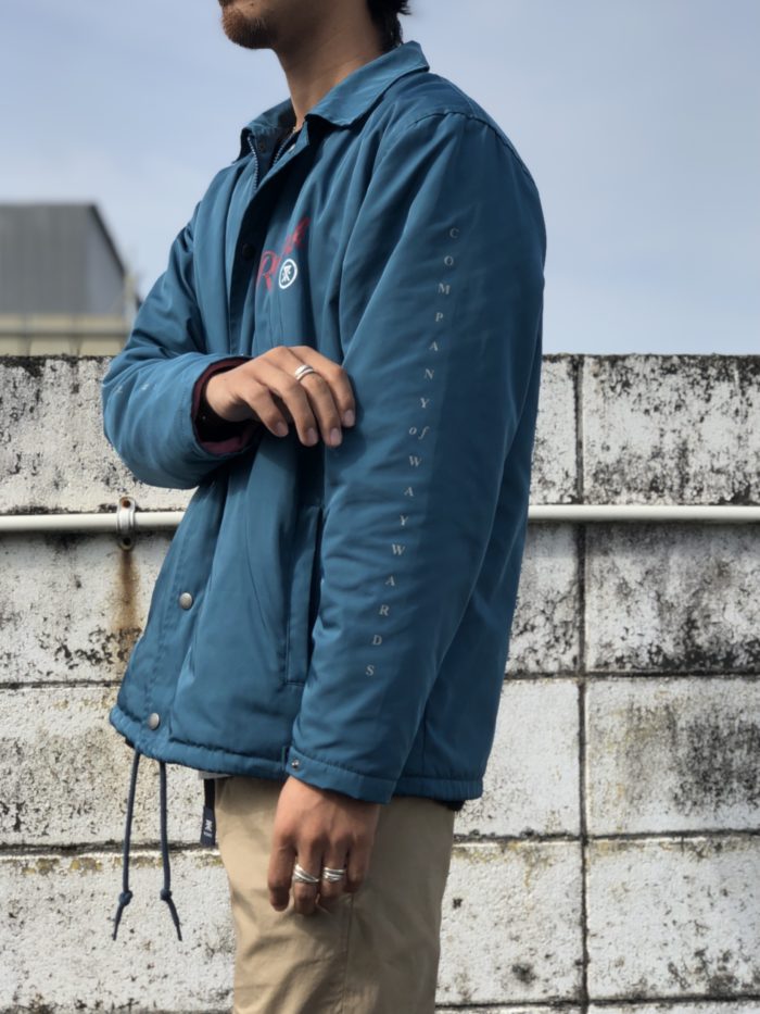 ROARK REVIVAL（ロアークリバイバル）の新作青色のジャケットに袖を通している男性